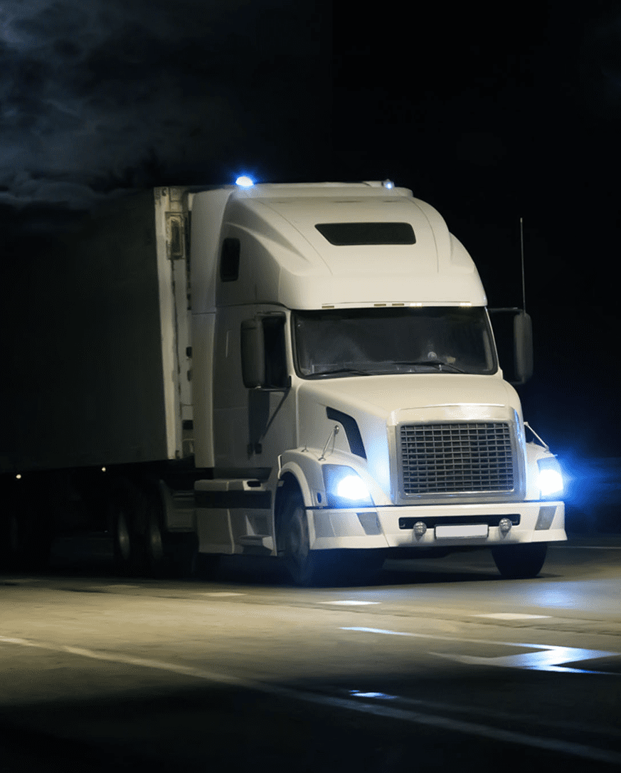 White truck driving on road at night.