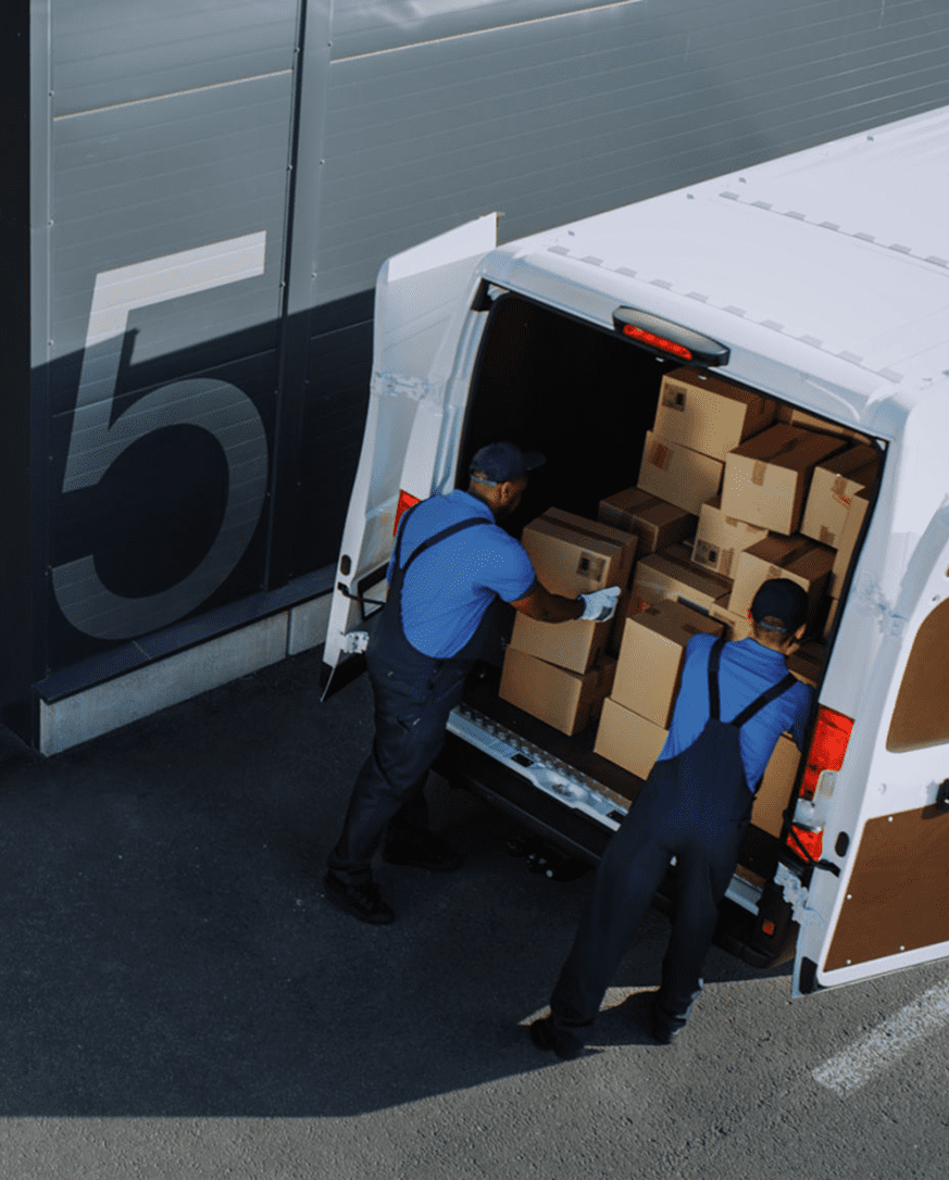 Workers loading packages into delivery van.
